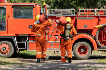 Firefighters wearing helmets with fire safety equipment Use Twirl aerosol fire extinguishers to...