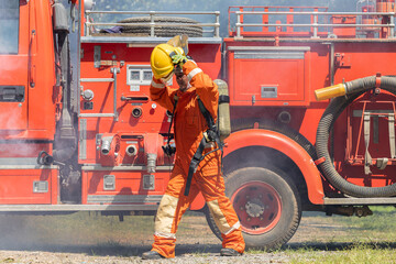 Firefighters wearing helmets with fire safety equipment Use Twirl aerosol fire extinguishers to fight oil flames.Preventing fire accidents is an industrial safety concept.
