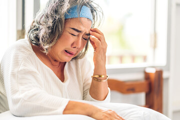 Portrait of depressed senior old adult elderly sad stressed asia women crying alone and felling upset on the bed at home
