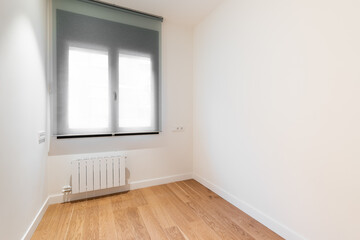Empty room with bright window, laminate flooring and newly painted white walls in refurbished flat