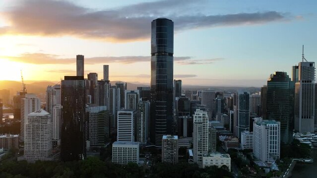 Aerial shot of Brisbane CBD, taken during sunset, golden hour shot, with skyscrapers standing above incredible sky. With Brisbane Botanical Gardens and river in shot as well.
