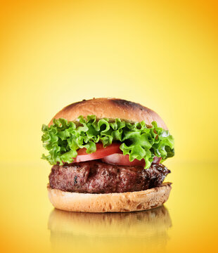 Homemade hamburger with large beef cutlet and fresh vegetables