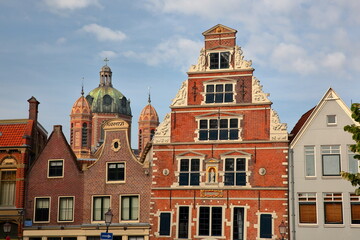Fototapeta na wymiar The colorful facades of historic houses located along Kerkstraat street in the city center of Hoorn, West Friesland, Netherlands, with the Butter House (Boterhal, built in 1563) in the center