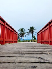 Palmen hinter einer roten Brücke