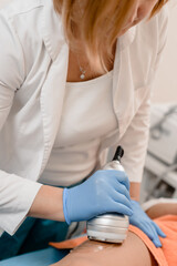 Female cosmetologist doing laser epilation procedure for female leg