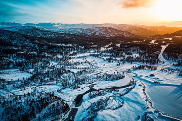 Winter landscape of the Setesdal in Norway - Panoramic view during sunset with snowy hills and a frozen river