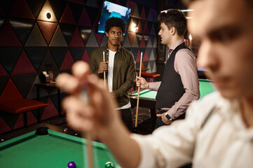 Young people friends or student playing billiards