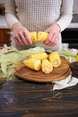 woman holding organic natural corn cob at domestic kitchen