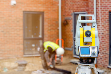 Surveyor optical equipment  tacheometer or theodolite on construction site close-up with selective focus and blurred background