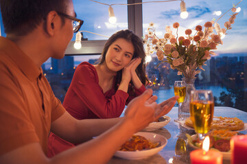 Young Asian couple eating dinner together
