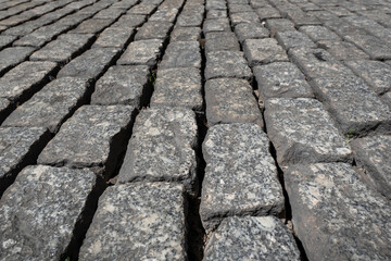 Cubos de granitos sobrepostos uns ao lado dos outros formando uma calçada portuguesa