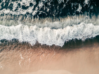 Waves on the sea coast. Beach with white sand and the blue sea.