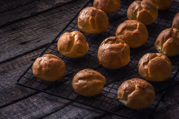 Homemade custard buns on a wooden background.