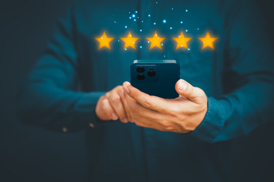 Man's Hand Using A Smartphone And Give Five Star Symbol To Increase Rating Of Product And Service Concept, Customer Service Experience, Testimonial And Business Satisfaction Survey.