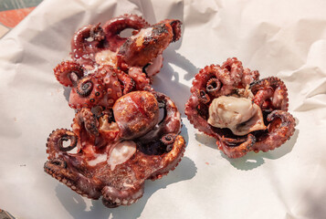 Freshly grilled octopused on a plate outdoor, Italy. Traditional Mediterranean cuisine.