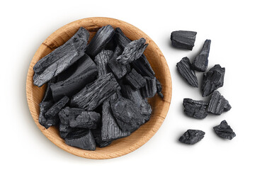 Natural charcoal in wooden bowl isolated on white background with full depth of field. Top view....
