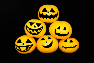 Triangular pyramid of tangerines with halloween emojis