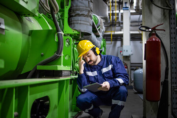 Factory engineer standing by gas generator and having a problem in electricity production inside...