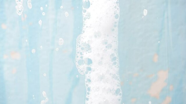 white soap bubbles flowing on abstract blue wall background texture