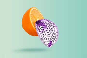 Obraz na płótnie Canvas Cut disco ball as an orange, floating in the air on a background.