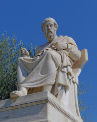 Fototapeta premium Plato, the ancient Greek philosopher marble statue, sitting and in deep thought under clear blue sky, Athens, Greece.