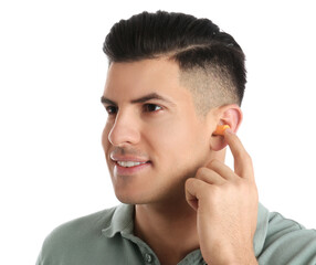 Man inserting foam ear plug on white background