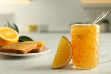 Delicious orange marmalade and citrus fruit slice on white table, closeup. Space for text