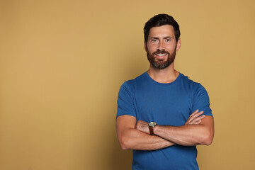 Portrait of handsome bearded man on yellow background, space for text