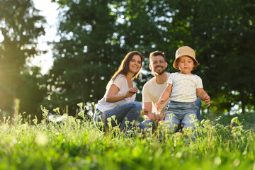 Fototapeta premium Happy cute family playing in park on sunny day