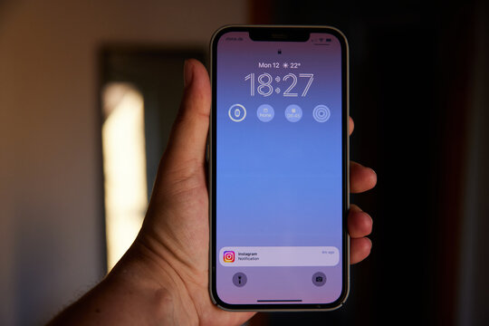 Close up of iPhone 12 Pro Max in Hand and Instagram Notification on Lock Screen