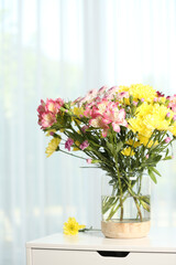Fototapeta na wymiar Vase with beautiful flowers on table near window indoors. Stylish element of interior design