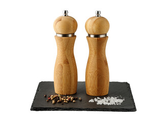 Wooden salt and peppers mill on black slate board isolated on white background. Two bamboo spice...
