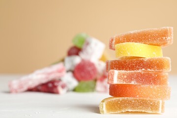 Pile of delicious bright jelly candies on white table. Space for text