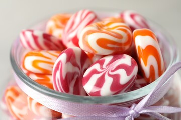 Delicious sweet candies in glass jar on light background, closeup