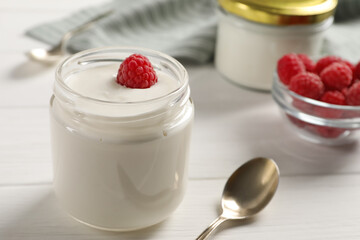 Bowl with delicious yogurt and raspberry on white wooden table, closeup