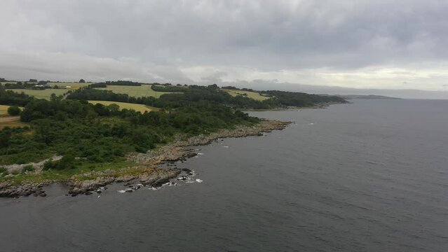 Drone flying cinematic over coastline at the sea in Denmark. The danish Island Bornholm in summer.