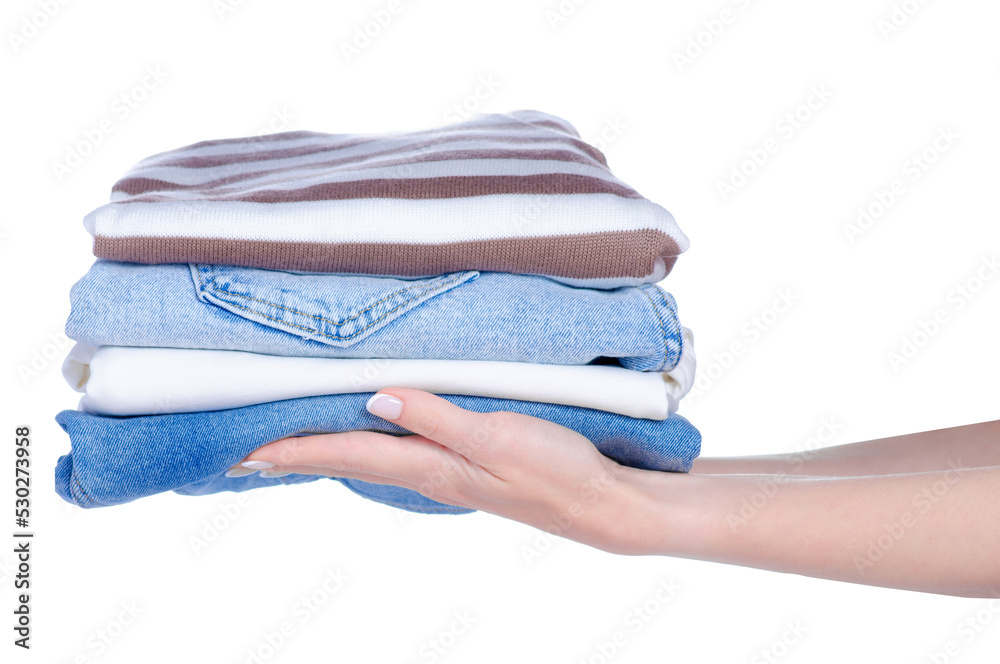 Wall mural Stack folded cloth jeans sweaters in hand on white background isolation