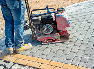 Construction work on the construction site, self-locking paving compaction with a vibrating plate,...