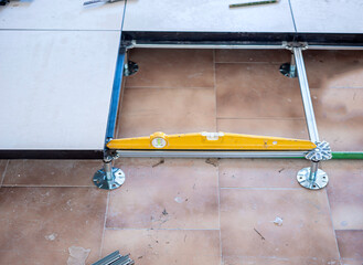 Worker install of raised floor in equipment room to spare space underground