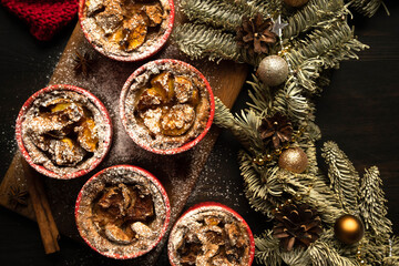 Christmas composition. Christmas cupcakes in red plates. Traditional holiday dessert. Copy space. Dark background. Flat lay.