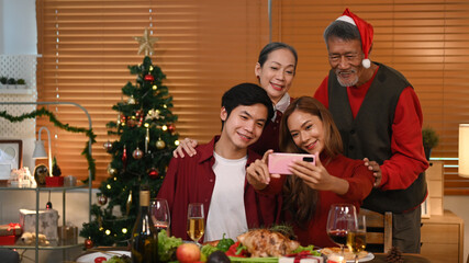 Happy family using smartphone and take selfie in room decorated for celebrating New year and Christmas festive