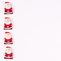 Four Santa Clous stickers on left side on white copy space background. Flat lay