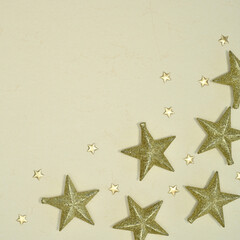 Fototapeta na wymiar Christmas glitter stars on pastel beige background with copy space. FLat lay