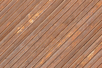 Wooden wall made of diagonal boards with light brown stripes. Background.