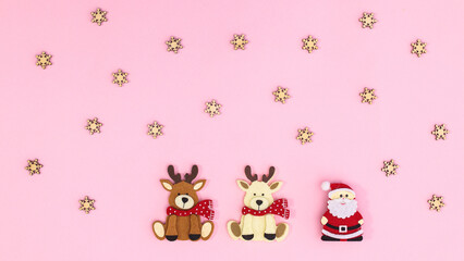 Christmas pastel pink background with Santa Clous and two reindeers. Flat lay