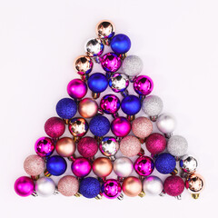 Creative Christmas tree shape with colorful glitter ornaments on white background. FLat lay