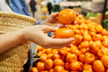 Kundin am Obststand beim Einkaufen von Mandarinen