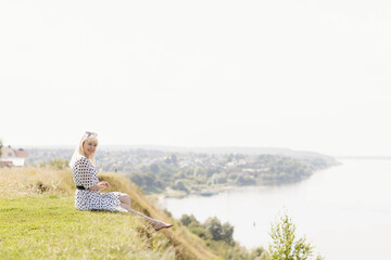 Naklejka na ściany i meble a girl in a white dress with black polka dots on the Sovereign's Mountain above the Volga River near the city of Mariinsky Posad