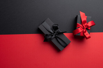 Composition of presents with pink and black ribbons on gray and pink background