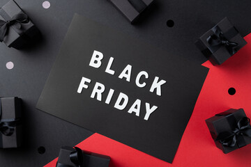 Composition of presents and black friday text on gray and pink background